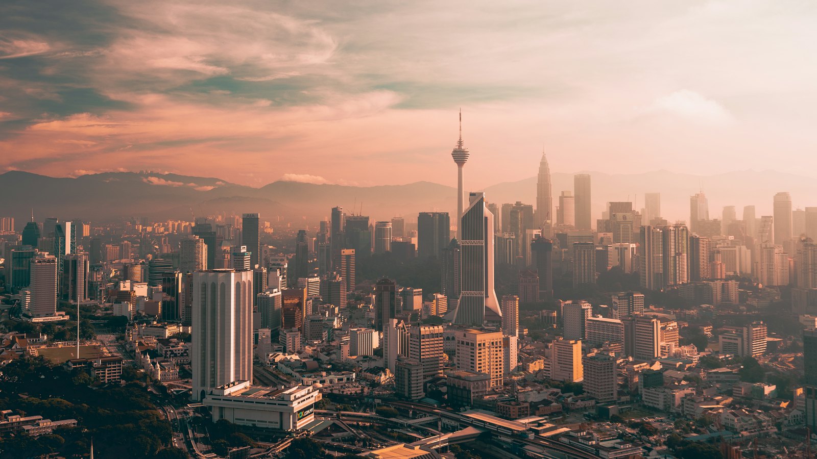 The Kuala Lumpur skyline at sunset, with KL Tower and the Petronas Twin Towers